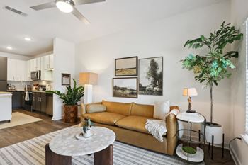A living room with a yellow couch and a white coffee table